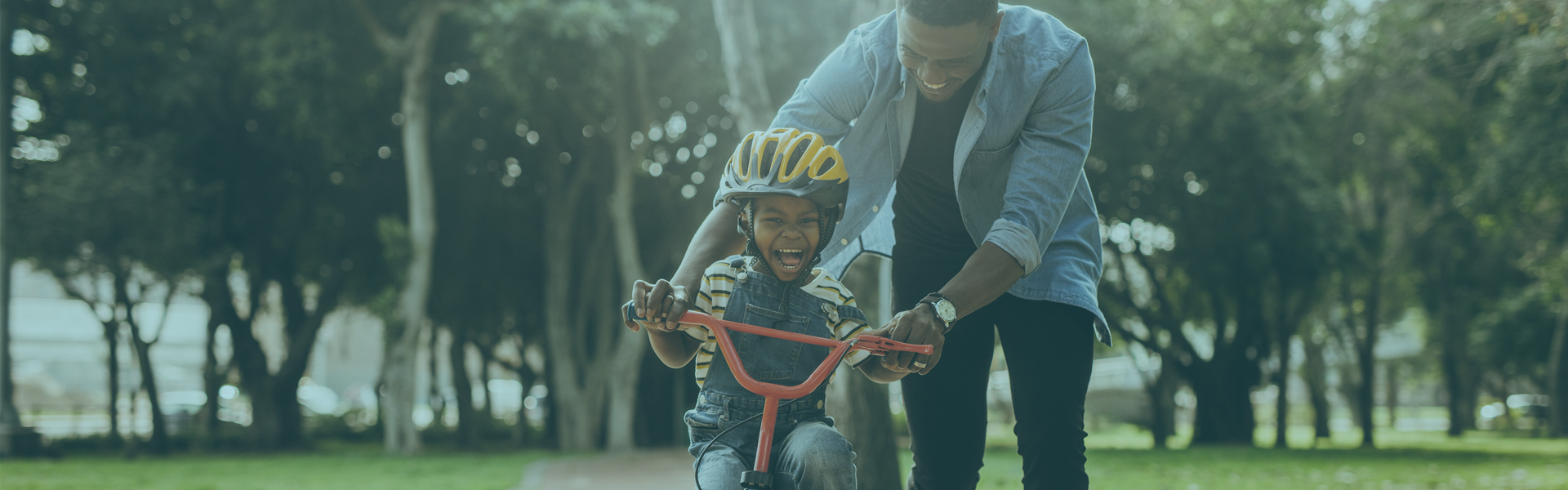 Father teaching son to ride bike | More Information